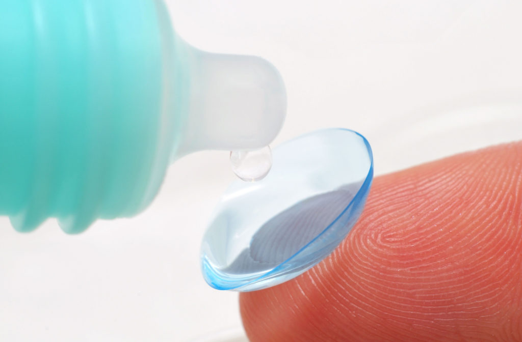 A close-up of a contact lens being cleaned using a cleaning solution.