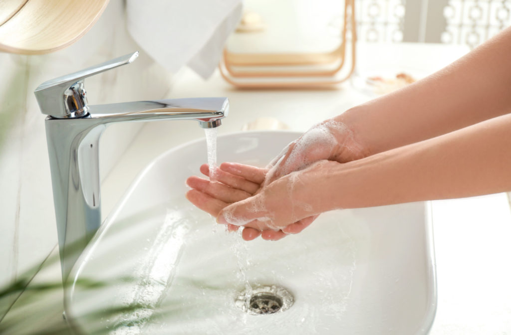 A person washing their hands using soap and water.