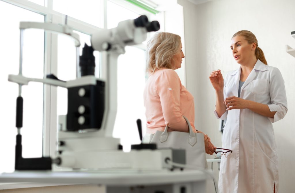 An older woman talking to her eye doctor, having a serious conversation.